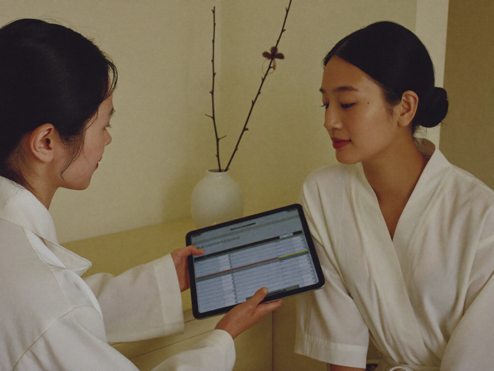 Therapist and guest reviewing progress chart on tablet