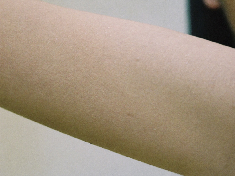 Close-up of smooth refined forearm skin texture in daylight