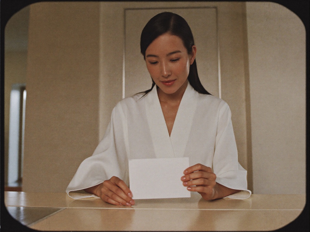 Guest in robe at studio reception counter holding care card
